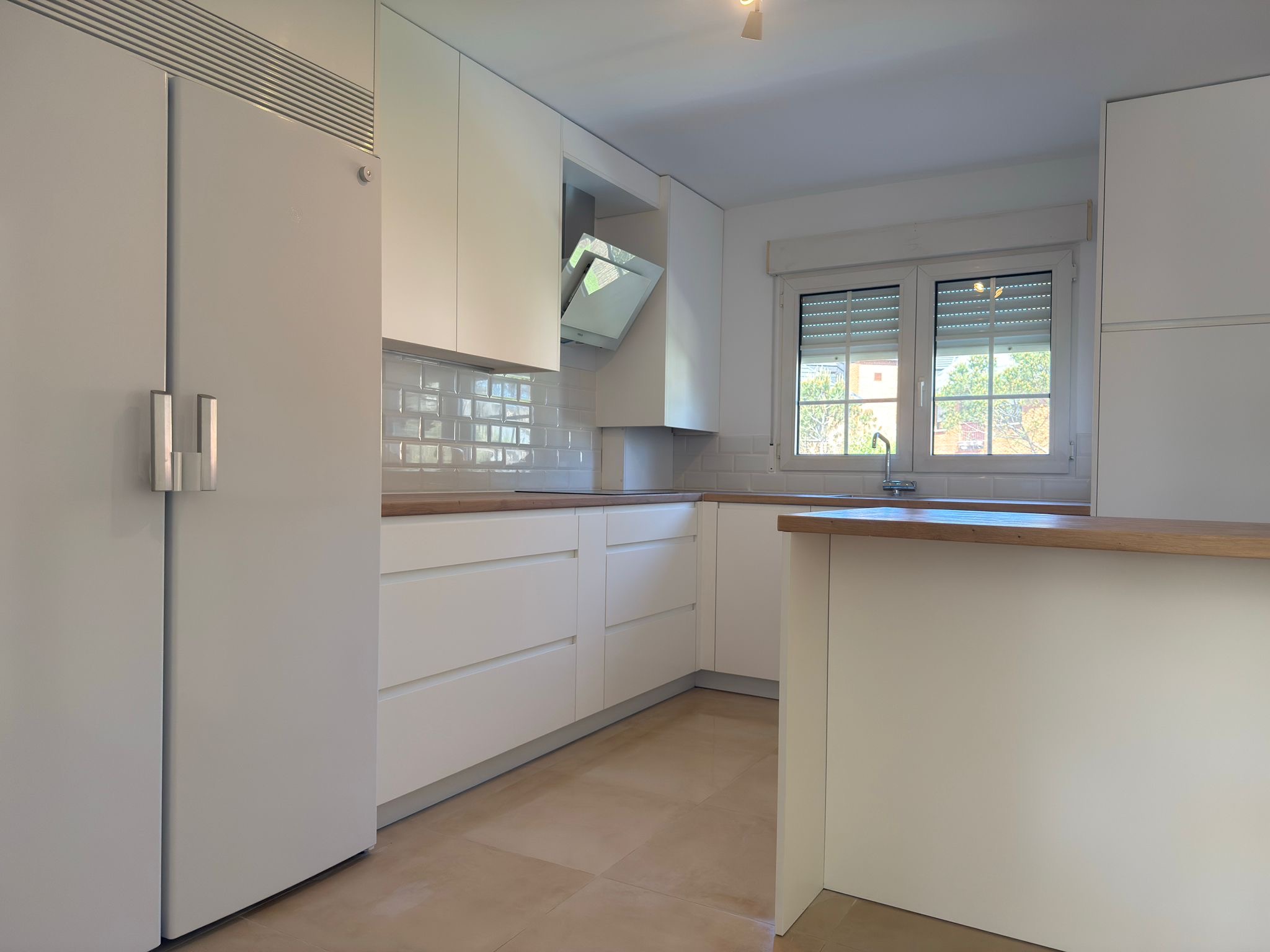 cocina minimalista blanca a medida Madrid con columna de armarios integrada